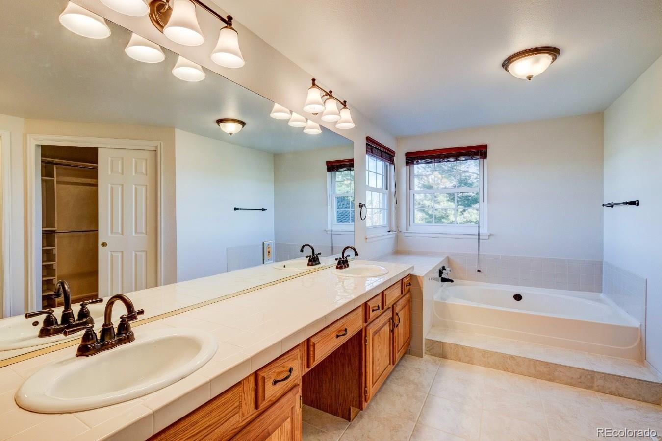 8927 Mountain Laurel Way Highlands Ranch, CO 80126 - Photo 20 of 35 a spacious bathroom with a bathtub double sink and a mirror