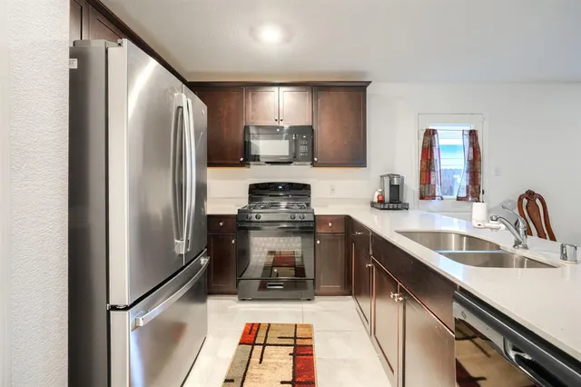 a kitchen with stainless steel appliances a refrigerator sink and stove