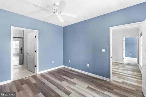 a view of a livingroom with wooden floor and a ceiling fan