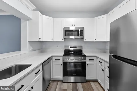 a kitchen with cabinets appliances and a sink