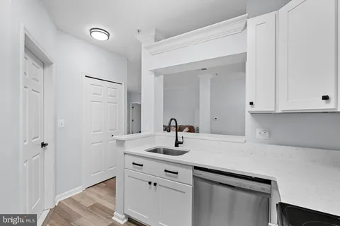 a kitchen with a sink cabinets and wooden floor