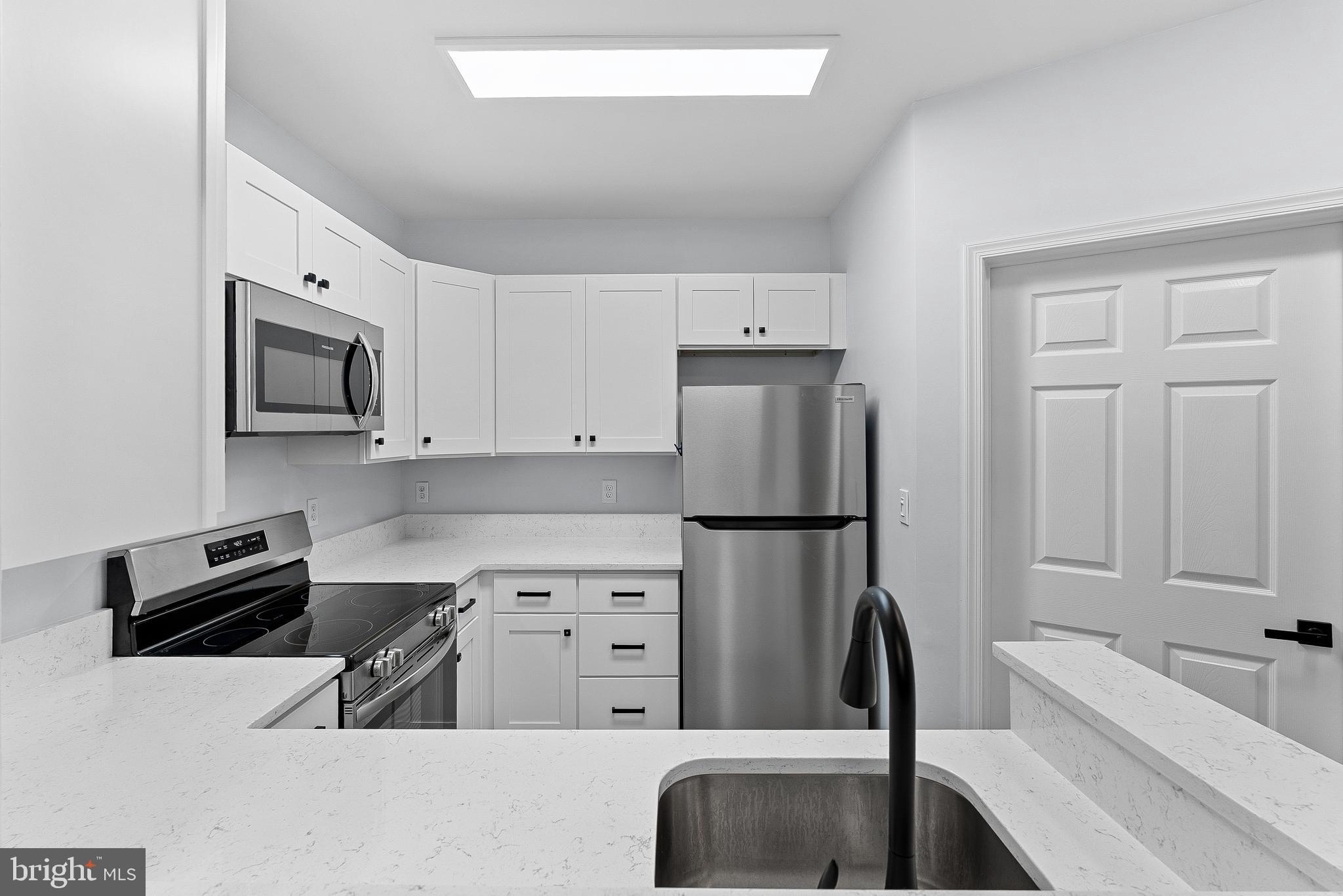 4551 Strutfield Lane, Unit 4111 Alexandria, VA 22311 - Photo 7 of 35 a kitchen with a refrigerator and a sink