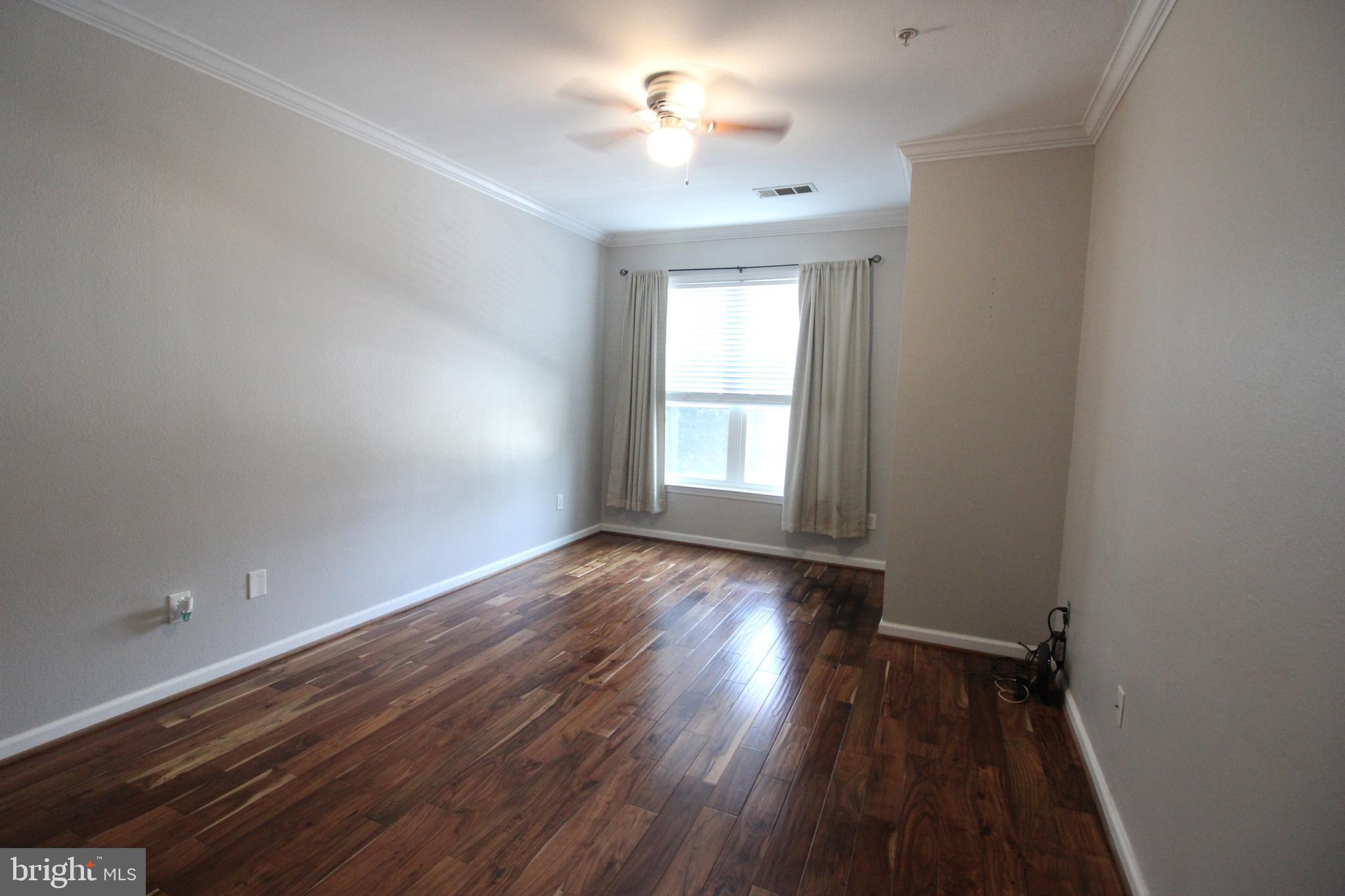 1570 Spring Gate Dr., Unit 7113 McLean, VA 22102 - Photo 2 of 8 wooden floor in an empty room with a window