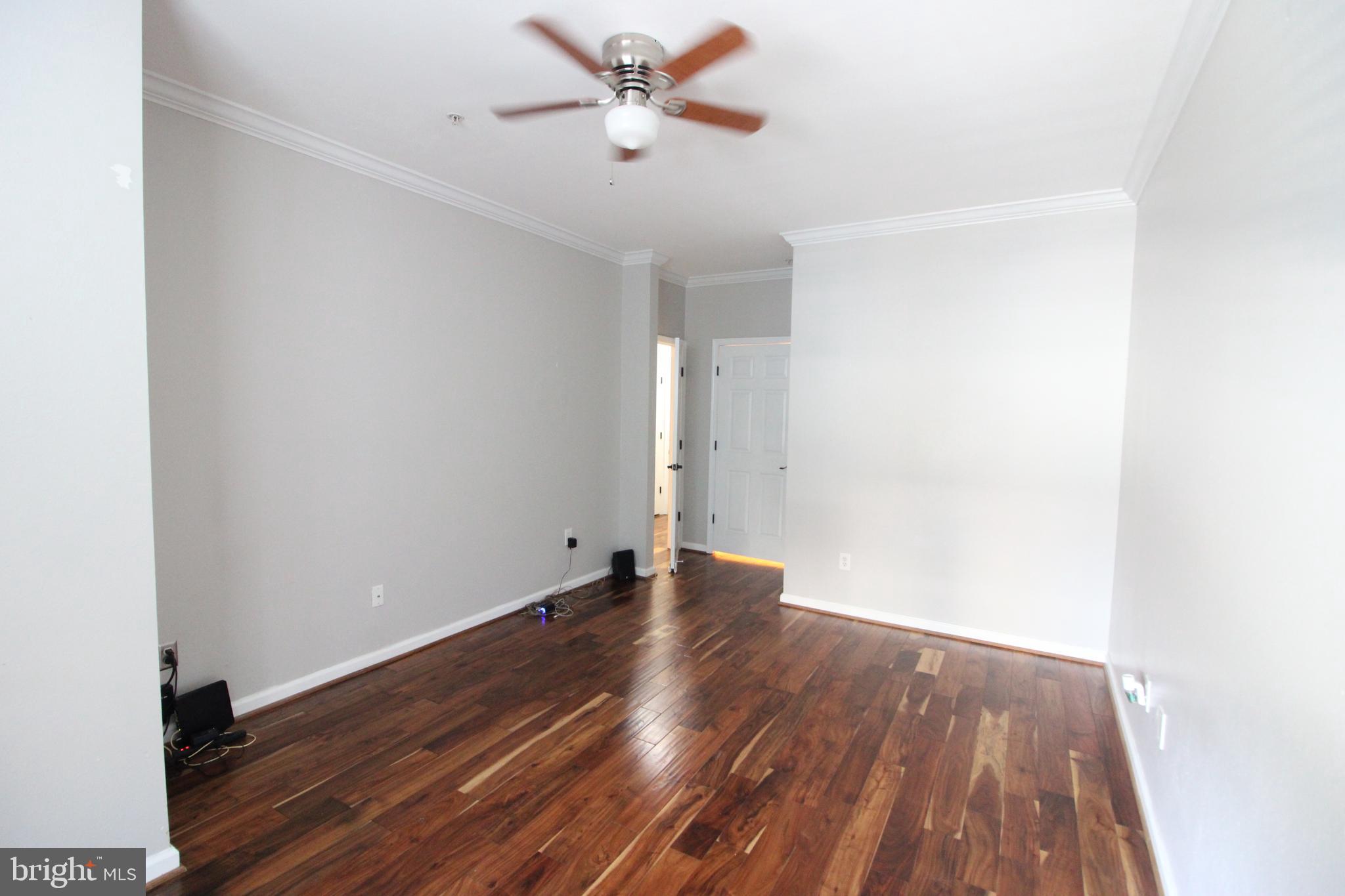 1570 Spring Gate Dr., Unit 7113 McLean, VA 22102 - Photo 3 of 8 a view of a room with wooden floor and a ceiling fan