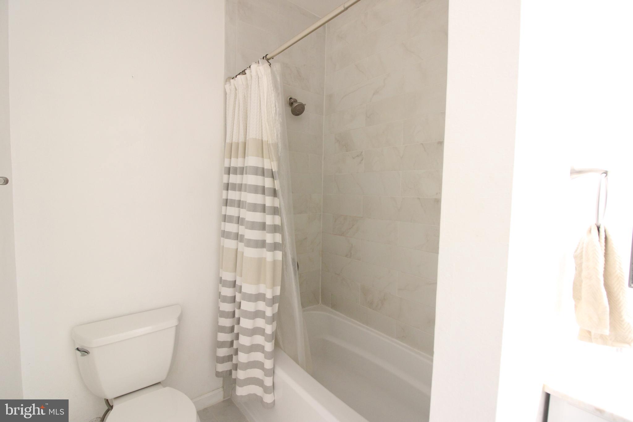 1570 Spring Gate Dr., Unit 7113 McLean, VA 22102 - Photo 5 of 8 a bathroom with a toilet and shower