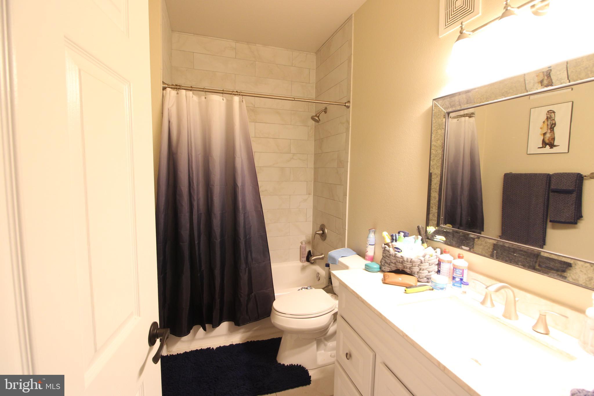 1570 Spring Gate Dr., Unit 7113 McLean, VA 22102 - Photo 8 of 8 a bathroom with a sink a toilet and shower curtain