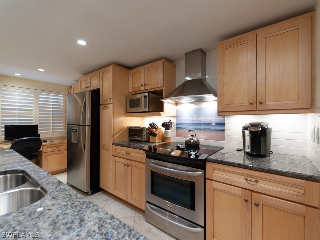 2445 West Gulf Drive, Unit E2 Sanibel, FL 33957 - Photo 11 of 35 a kitchen with stainless steel appliances granite countertop a sink stove and refrigerator