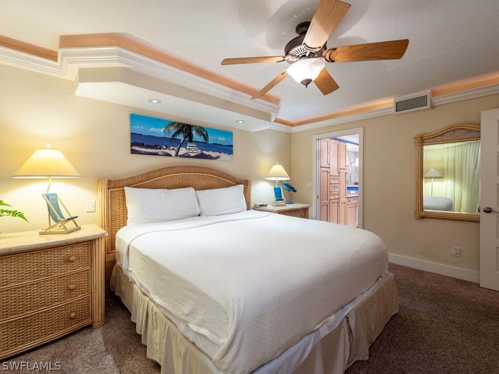 2445 West Gulf Drive, Unit E2 Sanibel, FL 33957 - Photo 23 of 35 a bedroom with a bed and a chandelier