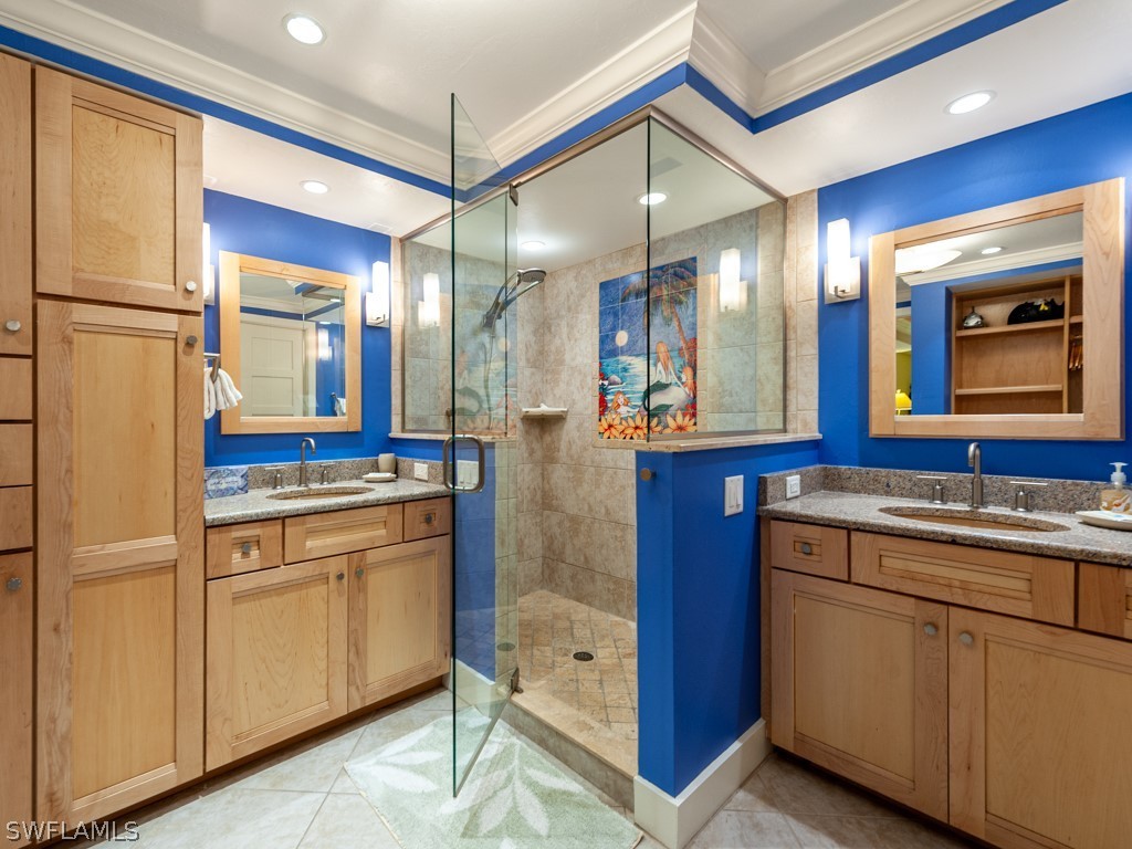 2445 West Gulf Drive, Unit E2 Sanibel, FL 33957 - Photo 25 of 35 a bathroom with a double vanity sink and mirror