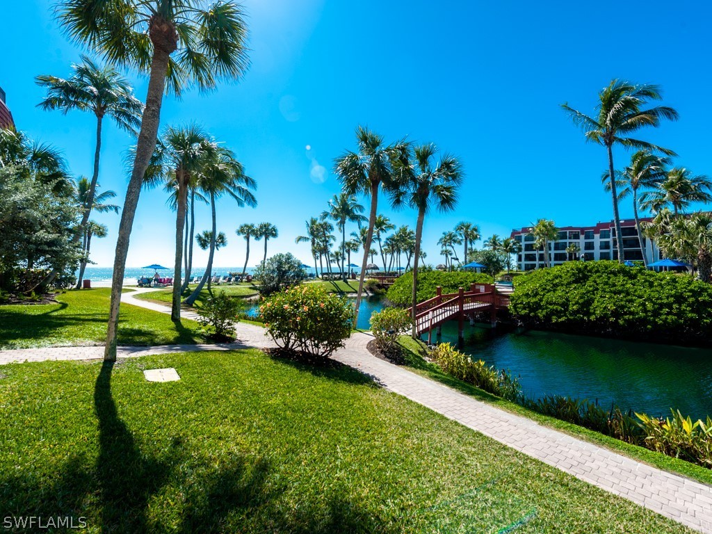 2445 West Gulf Drive, Unit E2 Sanibel, FL 33957 - Photo 30 of 35 a view of a lake with a big yard and palm trees