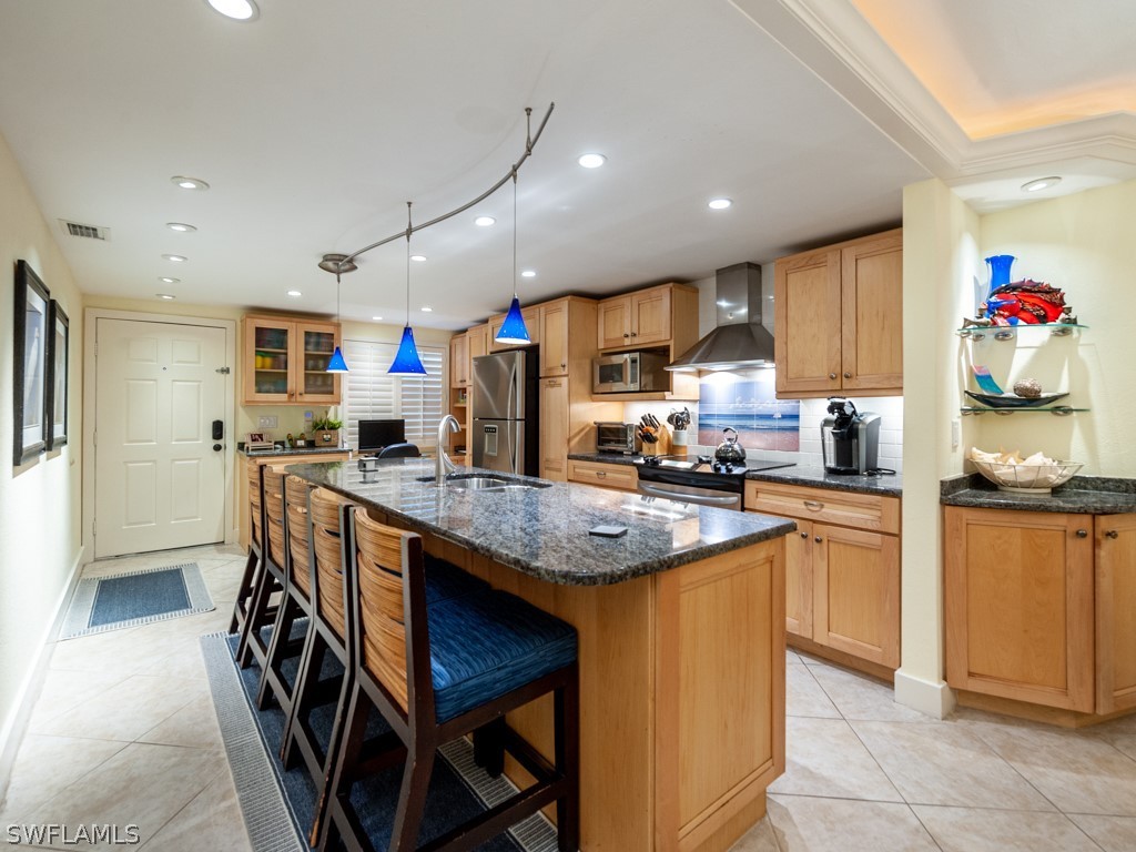 2445 West Gulf Drive, Unit E2 Sanibel, FL 33957 - Photo 5 of 35 a kitchen with granite countertop kitchen island stainless steel appliances a sink a counter top space cabinets and a window