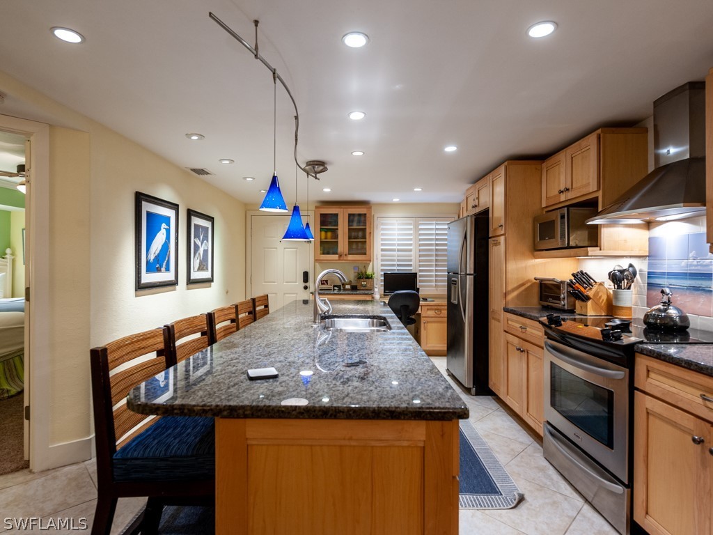 2445 West Gulf Drive, Unit E2 Sanibel, FL 33957 - Photo 7 of 35 a kitchen with stainless steel appliances granite countertop a sink and a refrigerator