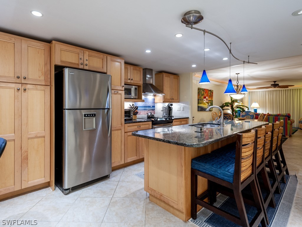 2445 West Gulf Drive, Unit E2 Sanibel, FL 33957 - Photo 9 of 35 a kitchen with stainless steel appliances granite countertop a table chairs and a refrigerator