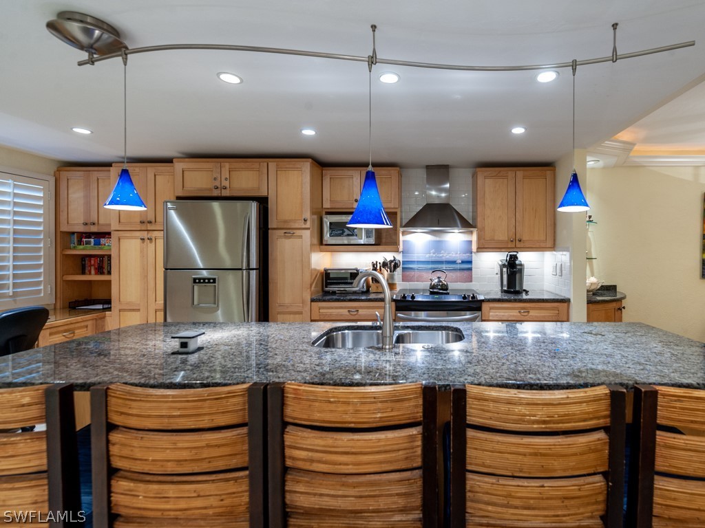 2445 West Gulf Drive, Unit E2 Sanibel, FL 33957 - Photo 10 of 35 a kitchen with kitchen island granite countertop wooden floor and a view of living room