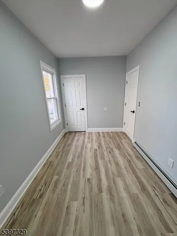 a view of a room with wooden floor and window