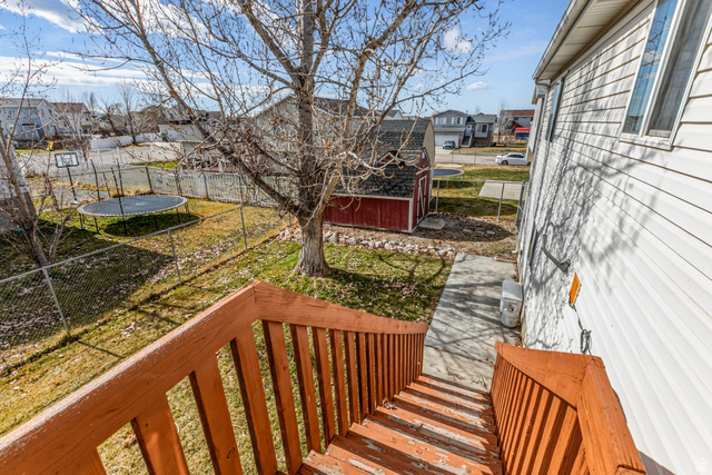 4239 West 5325th Street South Roy, UT 84067 - Photo 20 of 26 Wooden deck with a trampoline, a residential view, a fenced backyard, and a shed
