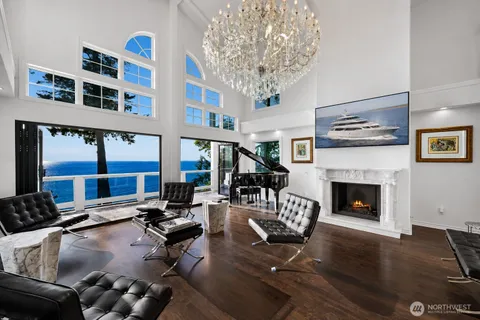 a living room with furniture a fireplace and large windows