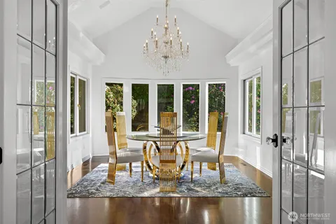 a living room with dining table and a chandelier