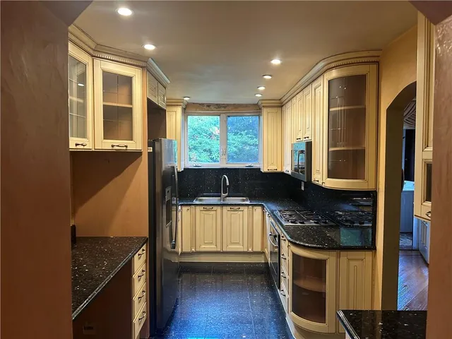 a kitchen with stainless steel appliances granite countertop a stove a sink and a microwave