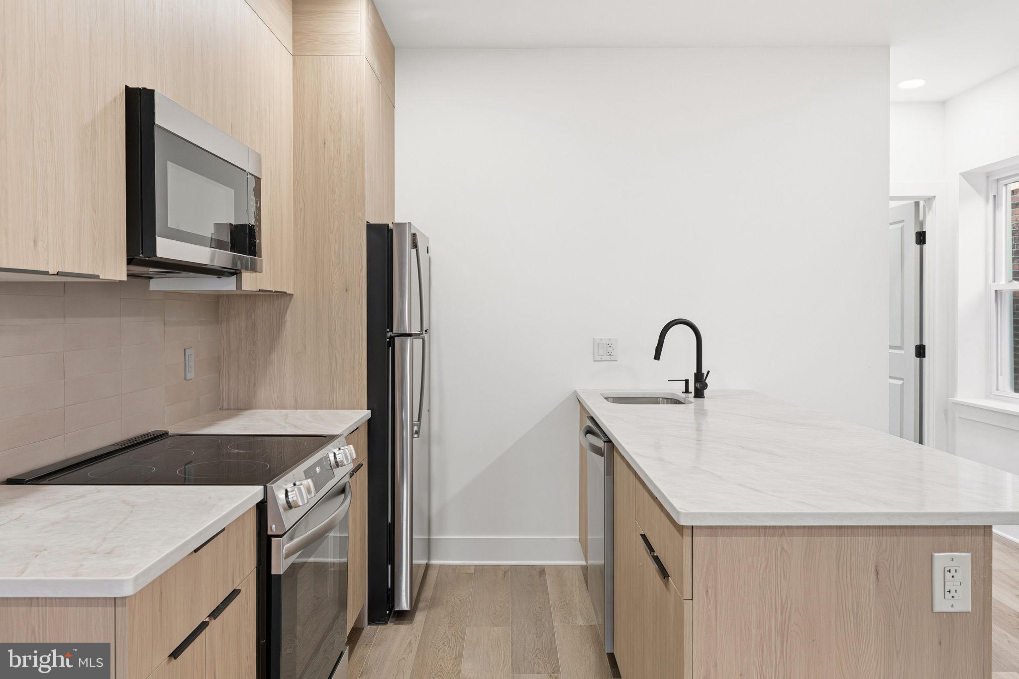 1502 South 52nd Street Philadelphia, PA 19143 - Photo 30 of 34 a kitchen with a sink and a refrigerator