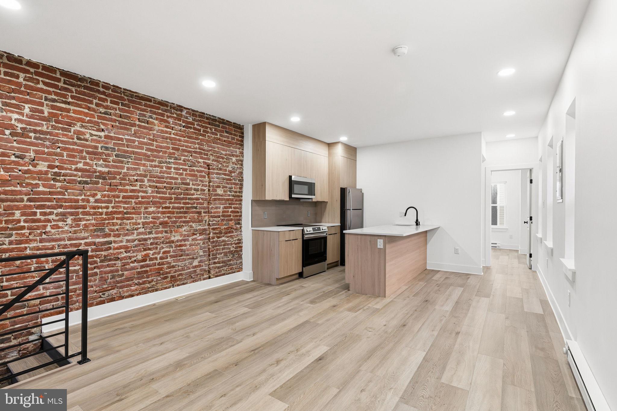 1502 South 52nd Street Philadelphia, PA 19143 - Photo 32 of 34 a kitchen with stainless steel appliances a refrigerator and a stove top oven