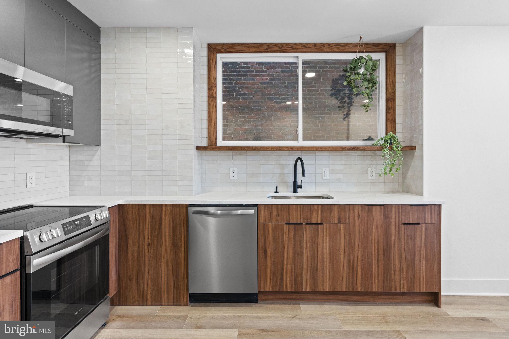 1502 South 52nd Street Philadelphia, PA 19143 - Photo 4 of 34 a kitchen with stainless steel appliances a stove sink and microwave