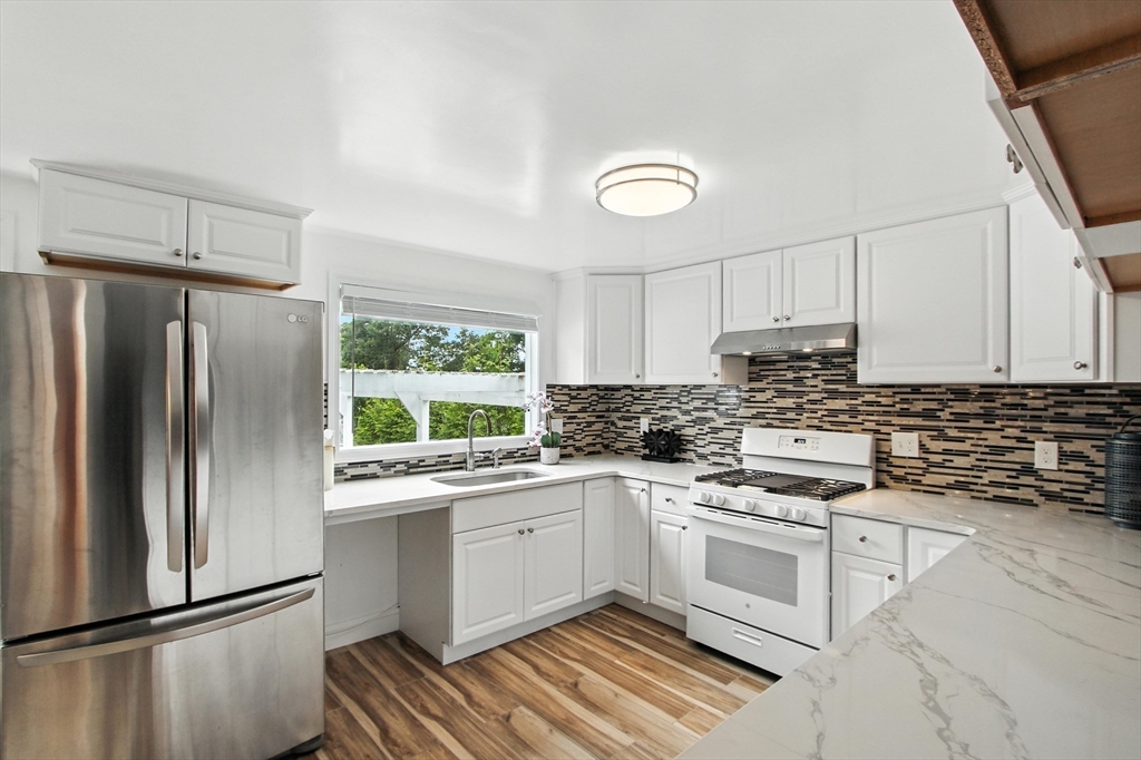 106 Home Park Road Braintree, MA 02184 - Photo 4 of 37 a kitchen with a white cabinets a sink a window and stainless steel appliances