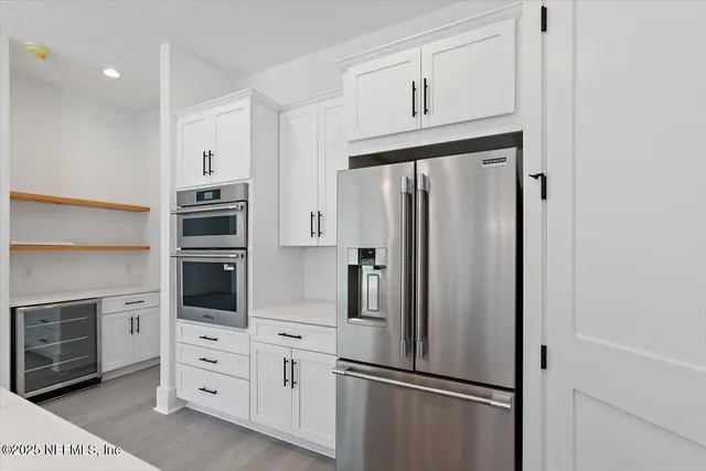 a kitchen with cabinets stainless steel appliances and a refrigerator