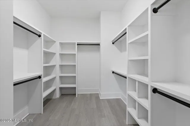 a view of walk in closet with empty racks