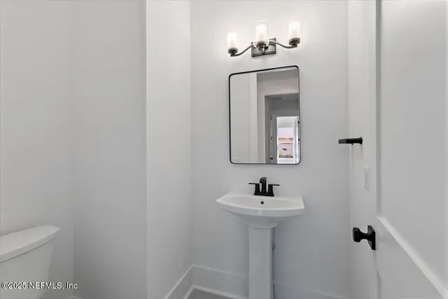 a bathroom with a sink a toilet and mirror