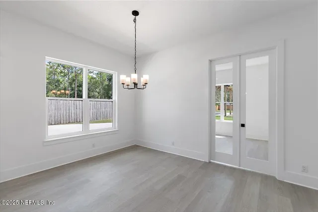 a view of empty room with wooden floor and windows