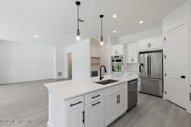 a kitchen with white cabinets and stainless steel appliances