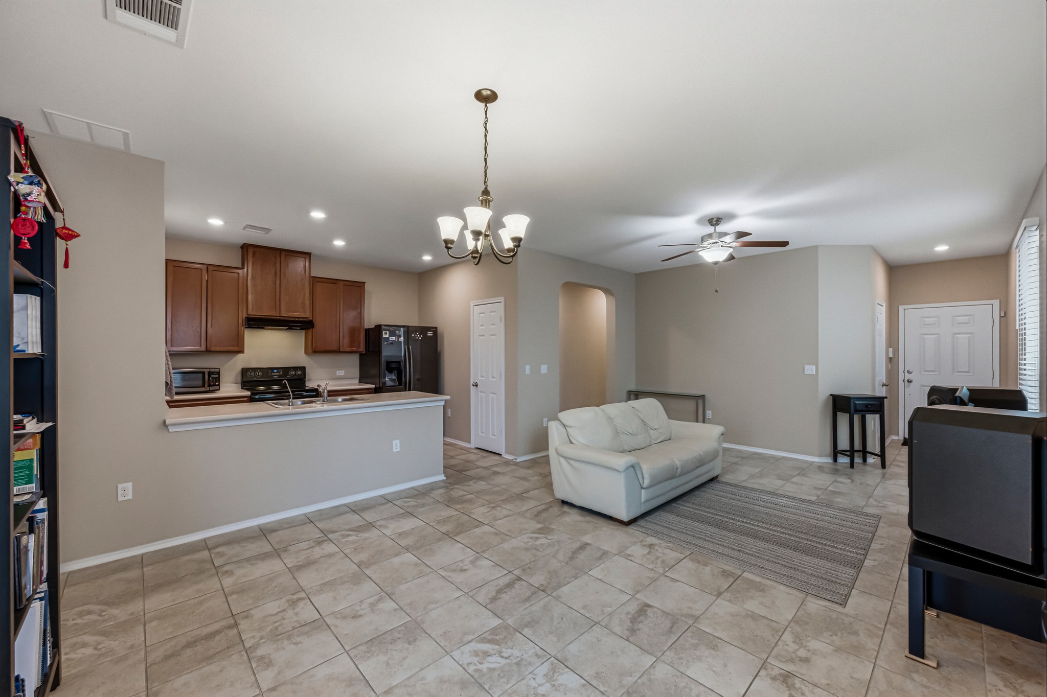 14620 Goshawk Drive Pflugerville, TX 78660 - Photo 5 of 24 a living room with kitchen island furniture and a chandelier