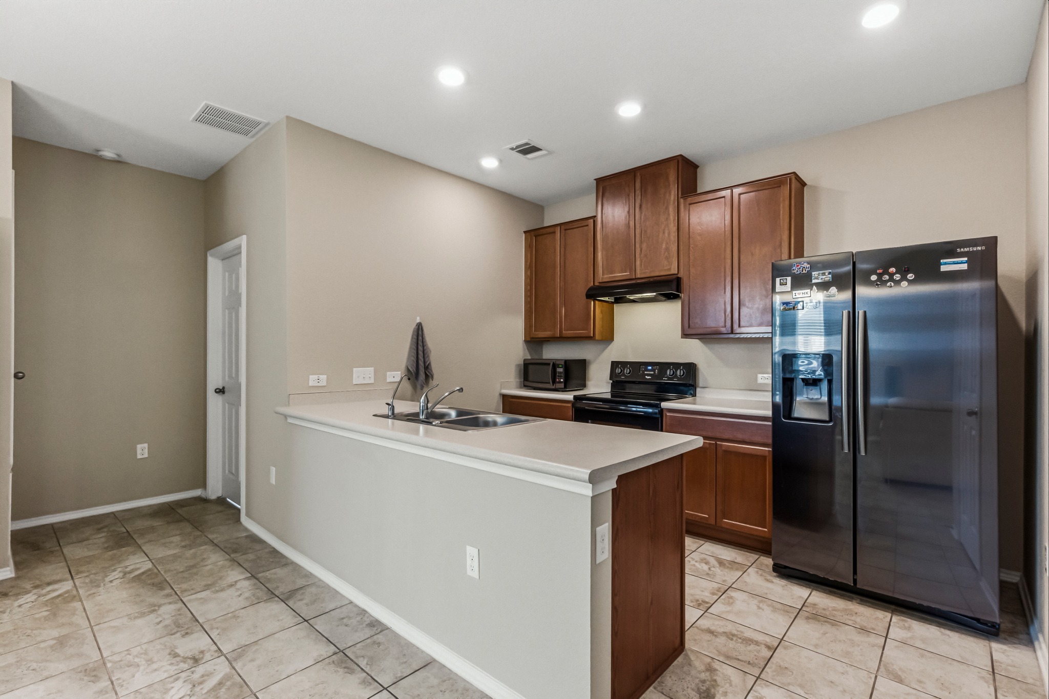 14620 Goshawk Drive Pflugerville, TX 78660 - Photo 7 of 24 a kitchen with refrigerator and cabinets
