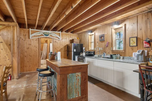 a kitchen with kitchen island granite countertop a sink a counter and chairs