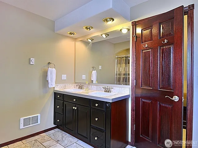 a bathroom with a double vanity sink and a mirror
