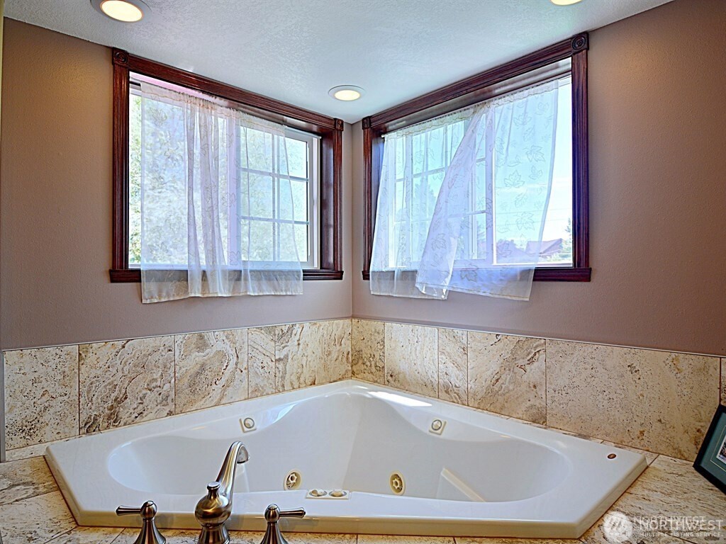 7842 Lake City Way Northeast Seattle, WA 98115 - Photo 12 of 36 a bath tub sitting in a bathroom next to a window