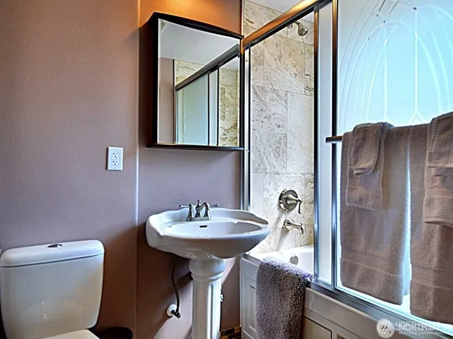 a bathroom with a sink a toilet and a mirror