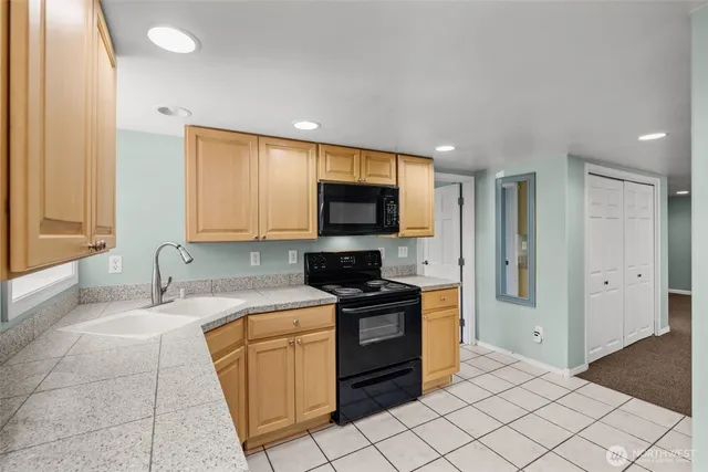 a kitchen with stainless steel appliances granite countertop a stove a sink and a refrigerator