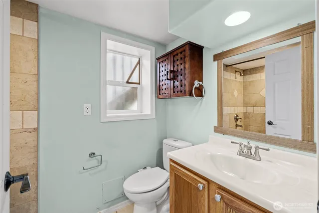 a bathroom with a toilet a sink and mirror