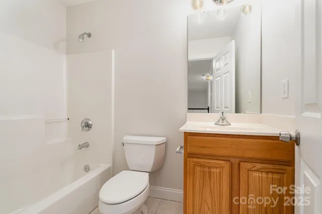 a bathroom with a granite countertop toilet a sink and a mirror