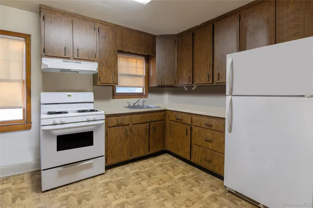 a kitchen with a refrigerator sink and cabinets