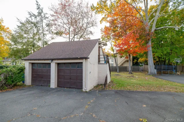 front view of house with a yard and trees