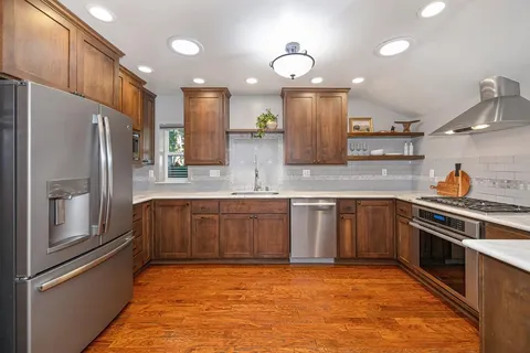 a kitchen with stainless steel appliances granite countertop a refrigerator and a sink