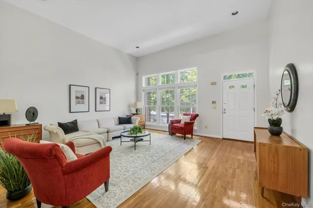 a living room with furniture floor to ceiling window and a flat screen tv