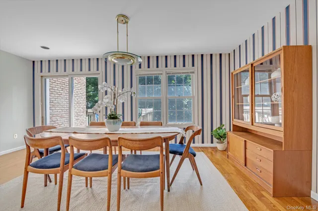 a dining room with furniture a chandelier and wooden floor