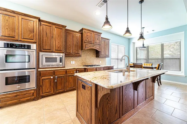 an empty room with chandelier fan and windows