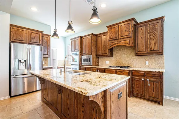 a large kitchen with stainless steel appliances granite countertop a stove and a sink
