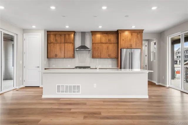 a view of kitchen with stainless steel appliances granite countertop a refrigerator a sink a oven and a large window