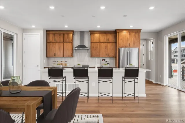 a kitchen with stainless steel appliances kitchen island granite countertop a stove a sink a dining table and chairs